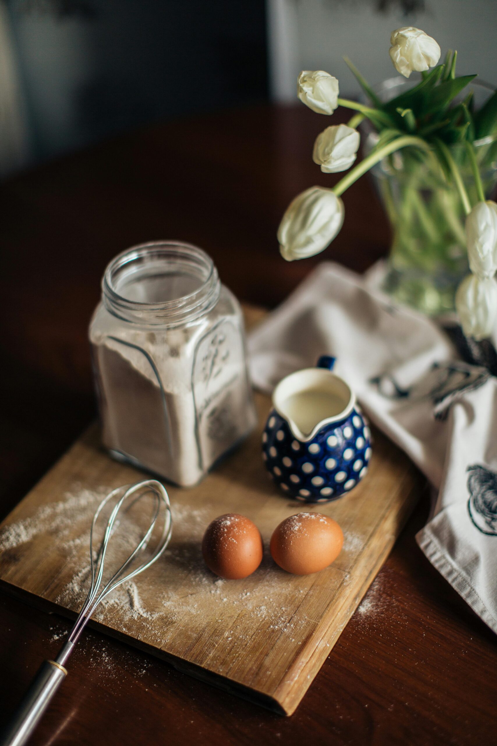 Kitchen setup with eggs, whisk, flour